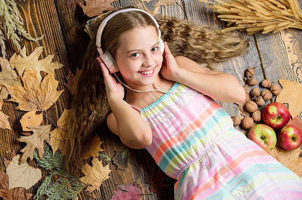 听起来节奏启发秋天女孩听音乐小女孩穿立体声耳机可爱的音乐风扇秋天背景可爱的孩子享受音乐玩耳机