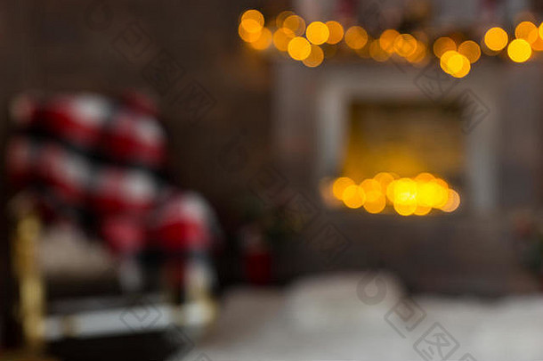 模糊图像舒适的生活房间摇摆椅子毯子装饰燃烧的壁炉发光的加兰