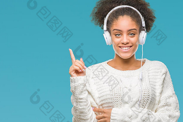 年轻的非洲式发型美国女人穿耳机孤立的背景快乐指出手手指一边