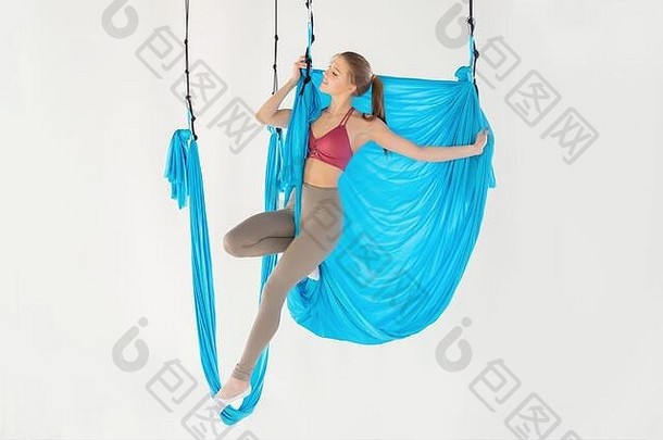 美丽的年轻的女人微笑练习航空飞瑜伽白色工作室蓝色的吊床概念伸展运动冥想