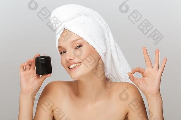 肖像美丽的微笑女人化妆白色毛巾头持有脸奶油手幸福的显示手势相机灰色的