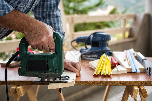 成人工匠卡彭特电工作切割木表格做家务股票摄影