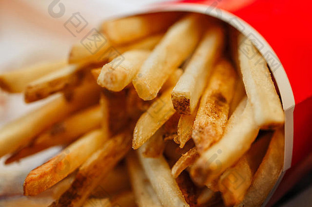 法国薯条土豆芯片红色的纸杯特写镜头宏拍摄不健康的炸餐快食物餐厅