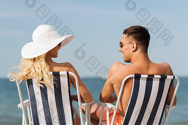 快乐夫妇日光浴椅子夏天海滩