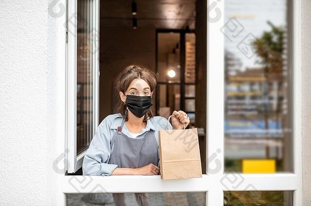 肖像咖啡馆小商店女工人保护面具窗口食物概念业务工作流感大流行