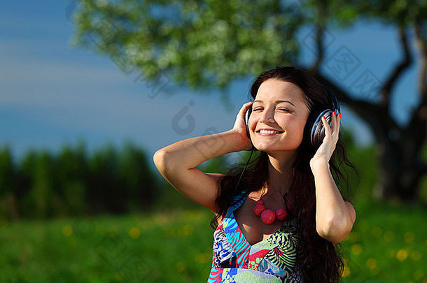 年轻的女人耳机听音乐场