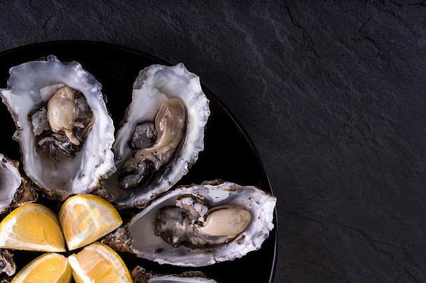 牡蛎板柠檬粉红色的背景新鲜的牡蛎特写镜头前视图健康的海食物牡蛎晚餐香槟餐厅美食食物