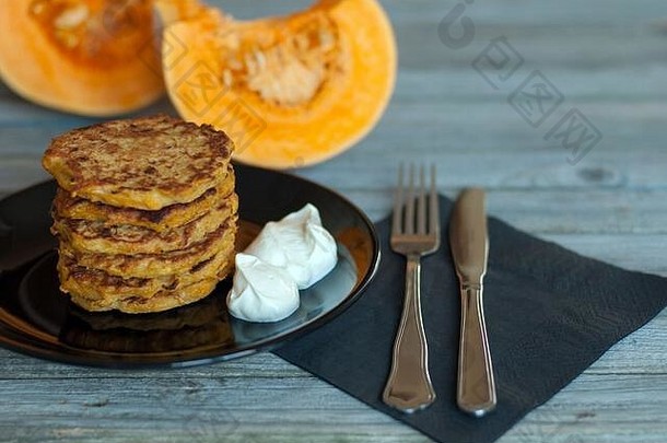 煎饼自然yougurt黑色的板叉刀纸餐巾服务灰色的木表格减少块橙色南瓜背景