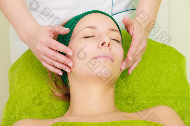 水疗中心放松护肤品健康的快乐概念女人说谎关闭眼睛放松脸按摩