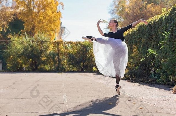 女人芭蕾舞女演员白色芭蕾舞裙子跳舞尖端鞋子秋天公园