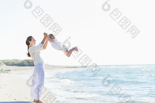 快乐妈妈。婴儿玩海滩