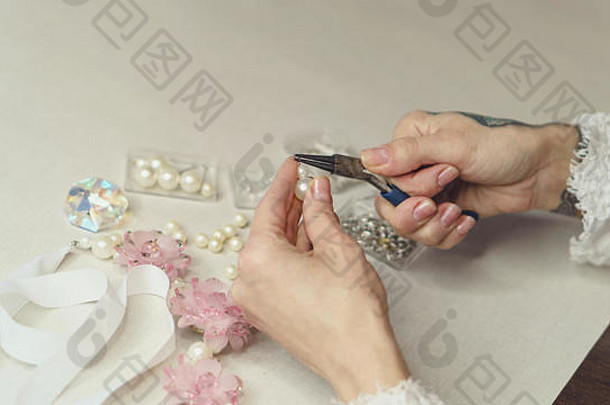 女孩时尚设计师使珠宝拍摄特写镜头弯曲轮销人工珍珠丝带人工花表