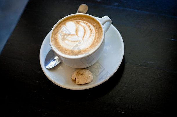 cappuchino拿铁咖啡白色杯心形状的泡沫饼干早....喝木表格咖啡白色杯子黑暗背景