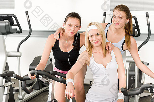 健身年轻的女孩健身房自行车室内有氧运动锻炼摆姿势