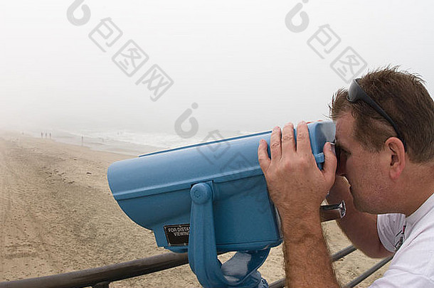 男人。的观点海滩游客支付视图望远镜码头