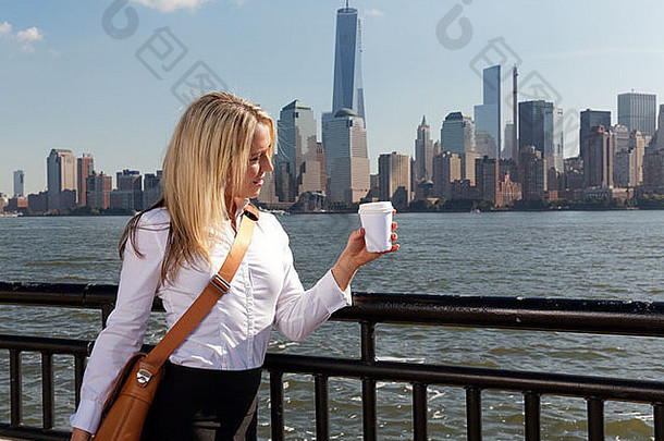 年轻的女人城市持有杯咖啡较低的曼哈顿天际线背景