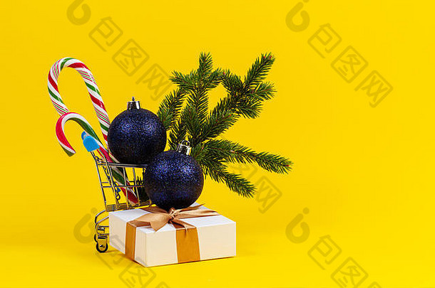 迷<strong>你购物</strong>车圣诞节装饰装饰物冷杉树分支糖果拐杖现在礼物盒子黄色的背景