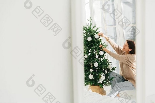 照片微笑年轻的女装修圣诞节树首页提出了大窗口白色复制空间左一边庆祝活动冬天时间