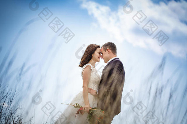 爱的夫妇新婚夫妇山时尚的新娘花束吻新郎爱忠诚阴影概念山