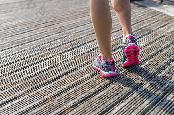 女人跑步者穿体育鞋子甲板