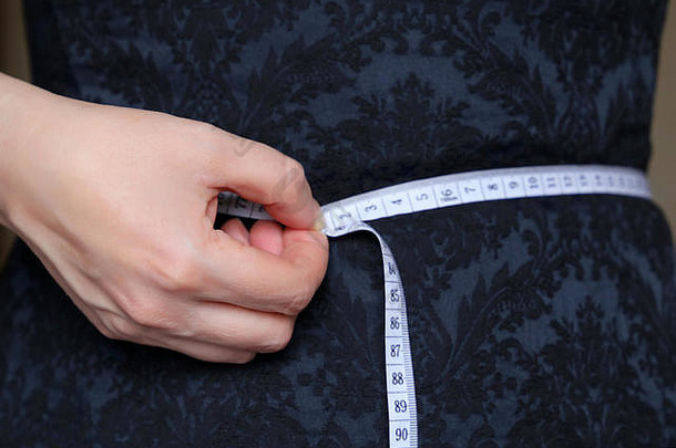 重量损失减肥饮食概念女孩蓝色的衣服测量磁带腰
