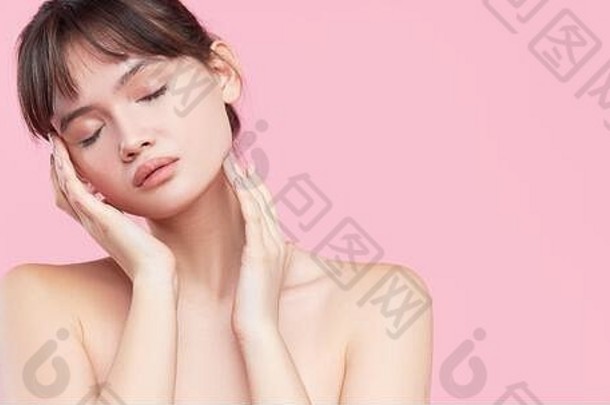 美丽的年轻的亚洲朝鲜文女人清洁新鲜的皮肤触碰脸脸治疗美容美水疗中心粉红色的背景