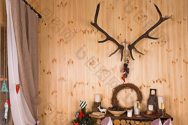 节日装饰安排圣诞节乡村的小木屋传统的饰品蜡烛香槟长笛架子上鹿鹿角安装木墙