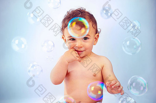照片可爱的婴儿男孩孤立的蓝色的背景甜蜜的孩子坐着玩肥皂泡沫可爱的孩子洗澡