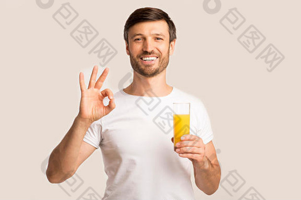 积极的男人。持有橙色汁玻璃手势白色背景