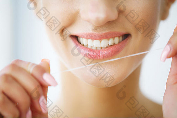 牙齿护理美丽的微笑女人用牙线清洁牙齿健康的白色牙齿高决议图像