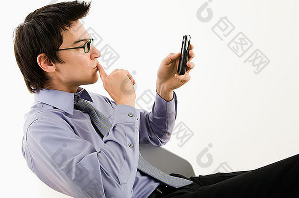 亚洲商人坐着桌子上发短信掌上电脑手机