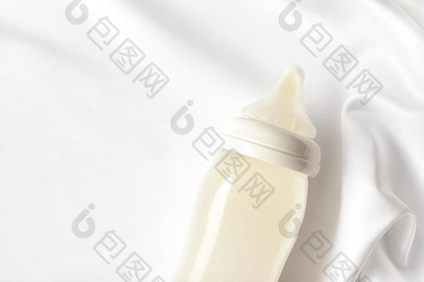瓶牛奶新生儿婴儿白色丝绸缎背景免费的复制空间孕妇婴儿护理概念前视图