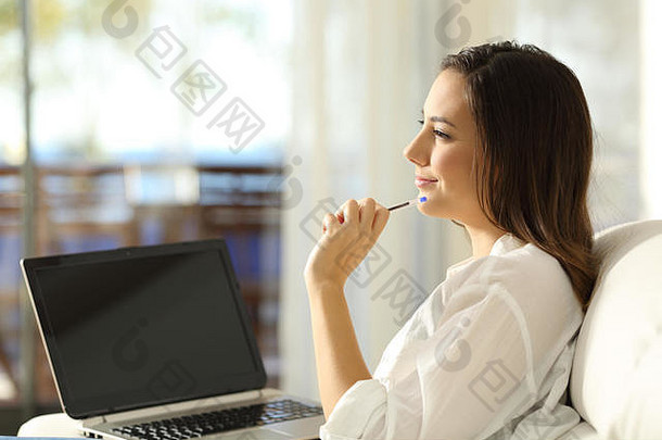 一边视图肖像女人思考一边显示空白移动PC屏幕坐着沙发上公寓