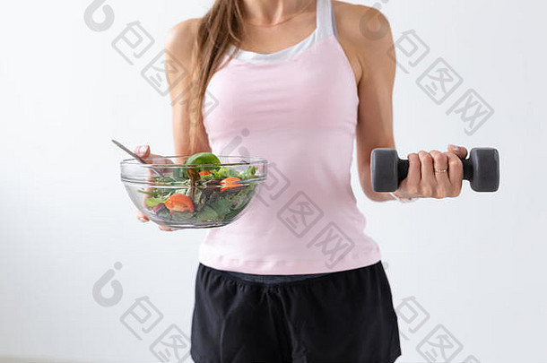 饮食食物健身概念关闭健康的沙拉哑铃女手白色背景