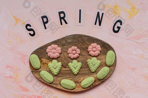 春天词花饼干木董事会粉红色的背景春天假期烹饪概念前视图平躺