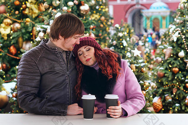 夫妇喝热饮料走圣诞节市场假期冬天圣诞节人概念快乐夫妇温暖的衣服在户外