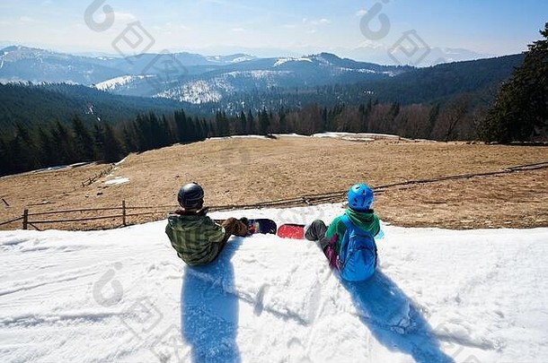 前视图单板滑雪休息坐着雪<strong>峰会</strong>享受美丽的视图<strong>背景</strong>蓝色的天空山山峰阳光明媚的冬天一天极端的冬天体育活跃的生活方式概念