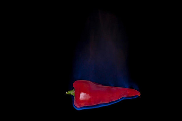 红色的胡椒火蓝色的火焰孤立的黑色的背景