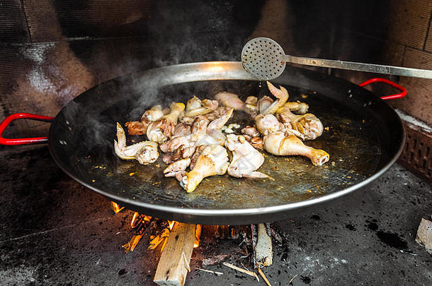 烹饪使传统的西班牙语西班牙海鲜饭开放火传统的准备valencian西班牙海鲜饭火木火焰大锅