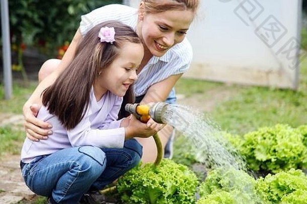 美丽的快乐妈妈。女儿工作农场花园