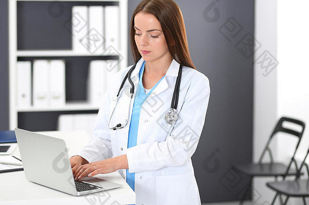 医生女人工作肖像女医生移动PC电脑站接待桌子上诊所紧急医院医学医疗保健概念