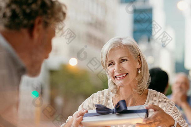 高级女人接收礼物丈夫城市人行道上咖啡馆