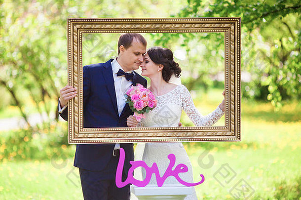 年轻的新婚新郎新娘粉红色的婚礼花束图片魔杖