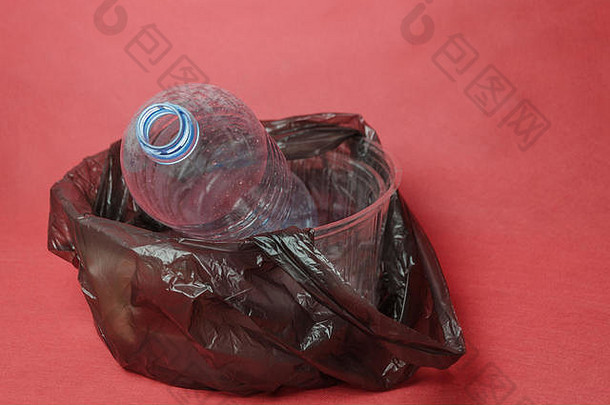 塑料透明的空瓶黑色的袋容器红色的背景空间文本概念环境污染塑料