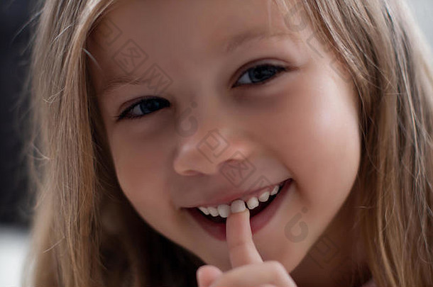 蓝眼睛的金发碧眼的女孩笑着说显示牙孩子们的牙齿损失