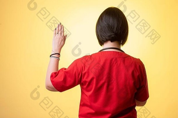 肖像美丽的女人医生听诊器穿红色的实习医生风云显示誓言摆姿势黄色的孤立的背景