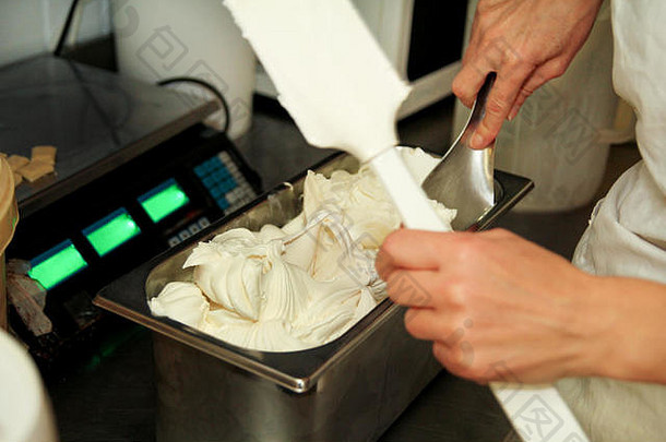 女人工作冰奶油工厂装饰奶油香草白色巧克力冰奶油说块巧克力钢容器