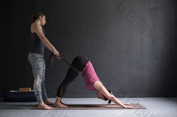 瑜伽老师普拉提教练帮助年轻的女人拉伸肌肉