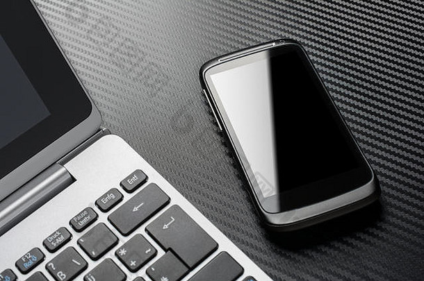 业务工作黑色的智能手机反射说谎笔记本键盘碳层