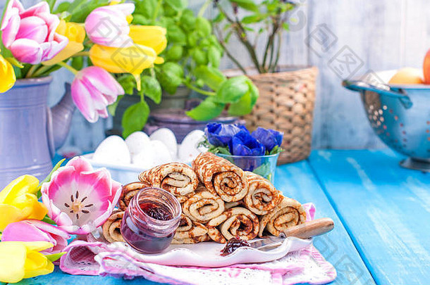 自制的传统的煎饼小时春天狂欢节俄罗斯早餐明亮的花郁金香蓝色的背景免费的空间文本明信片